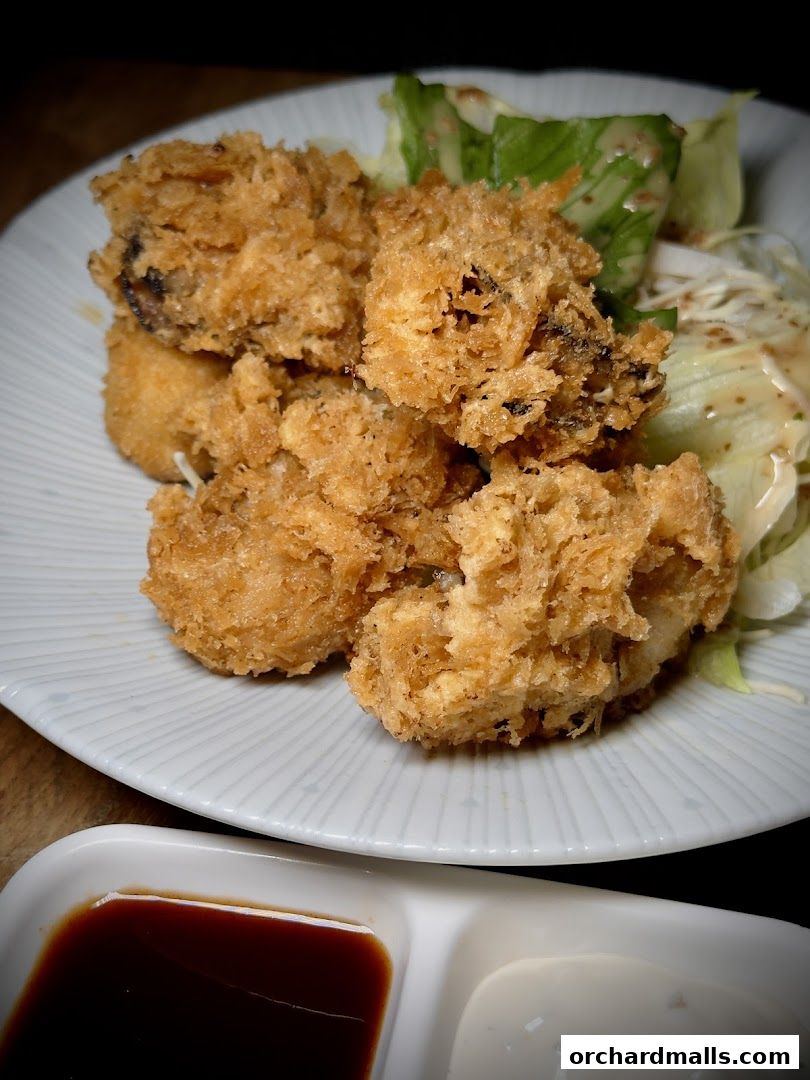 Crispy fried oysters served with a side salad and dipping sauces.