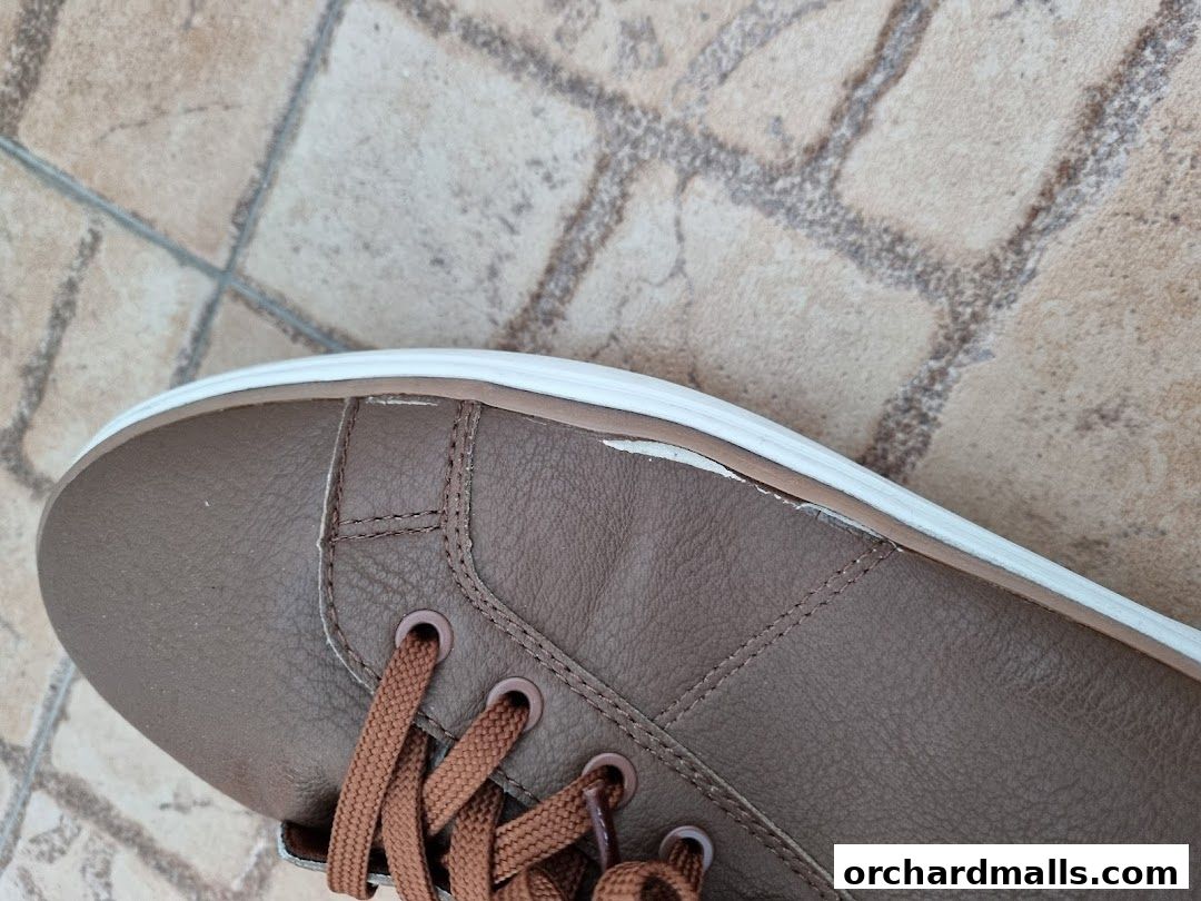 Close-up of a brown leather shoe with white sole and brown laces.