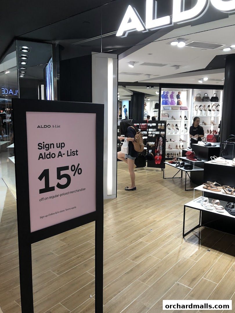 ALDO store interior with shoes and bags displayed, and a sign offering 15% off.