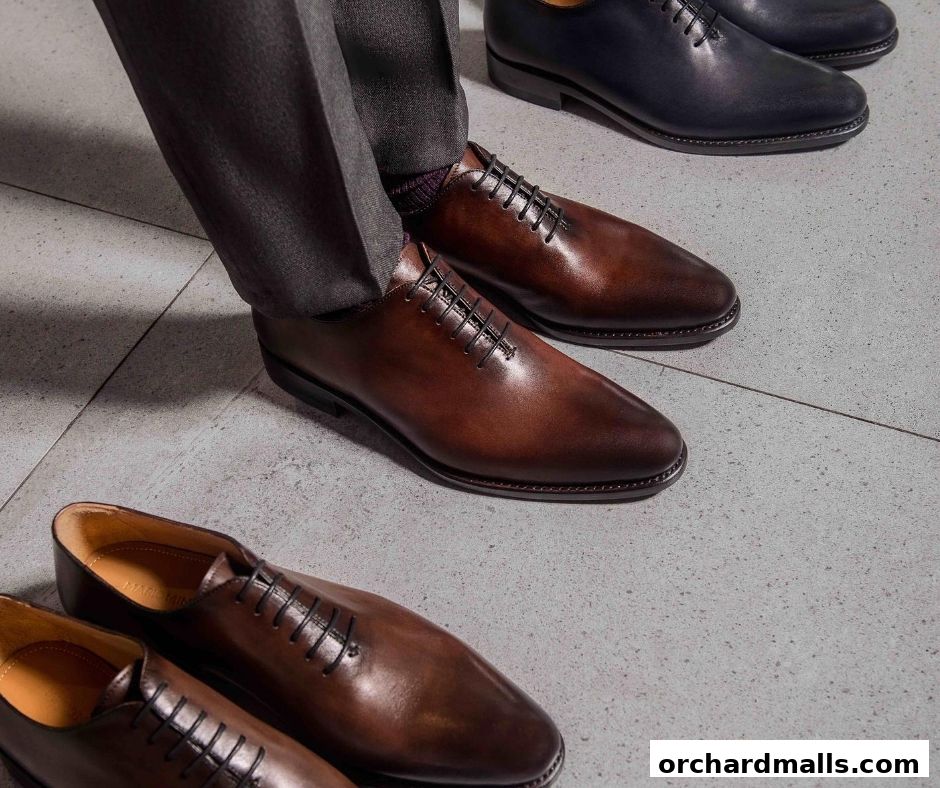 Close-up of men's dress shoes in brown and black, showcasing craftsmanship and style.