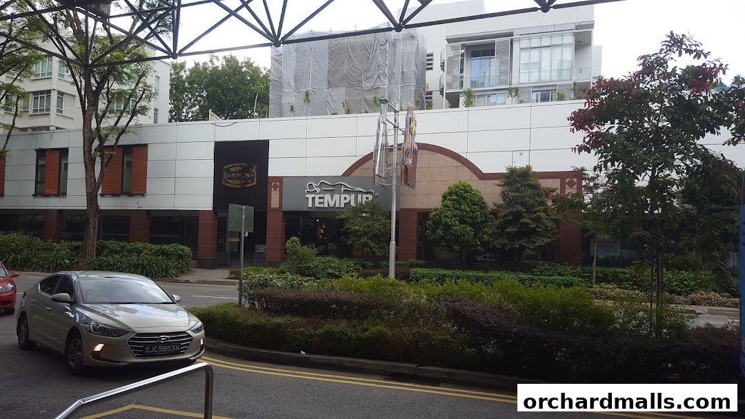Exterior view of Simmons and Tempur shops with a car driving by.