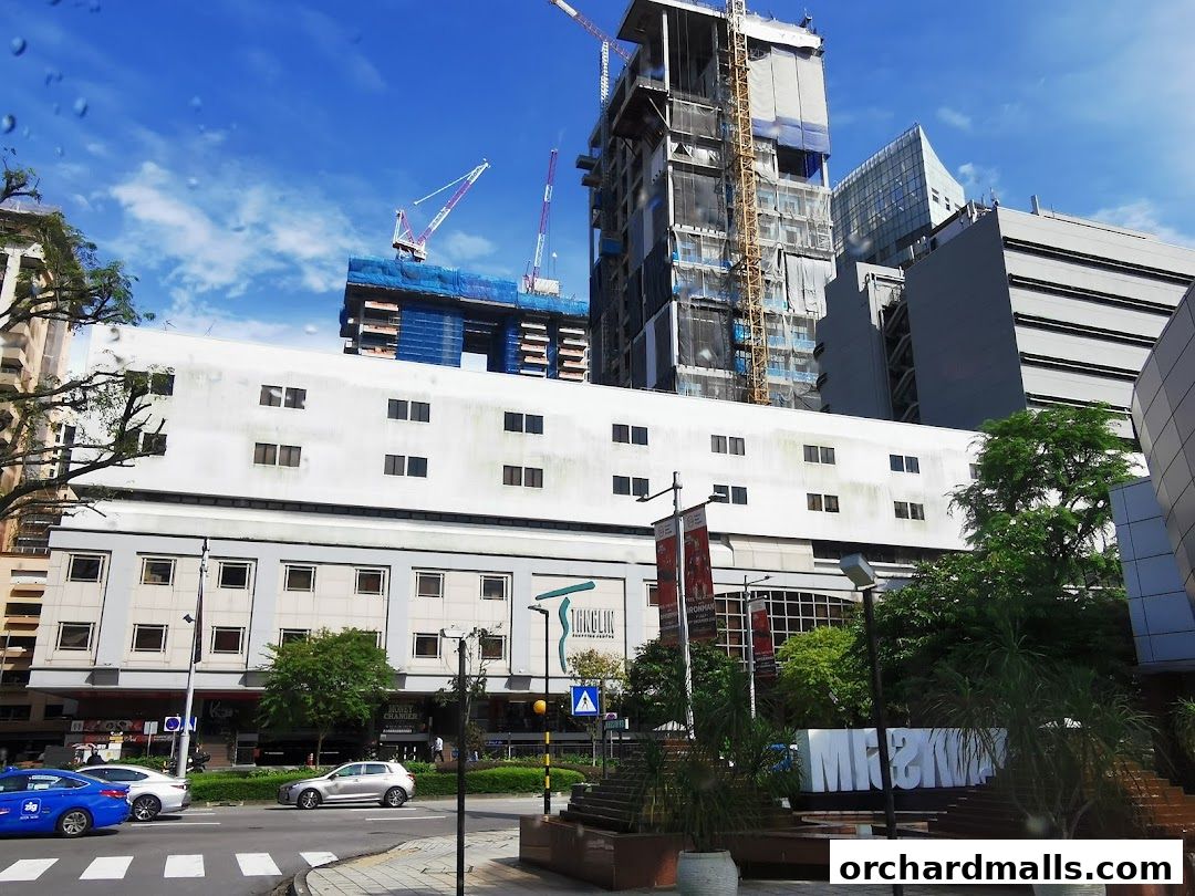 A street view of a building with construction cranes in the background and a sign for 'Andric Leasing'.