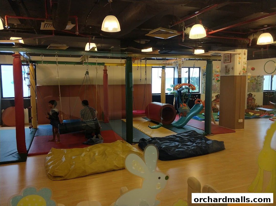 Indoor children's play area with swings, slides, and soft play equipment.