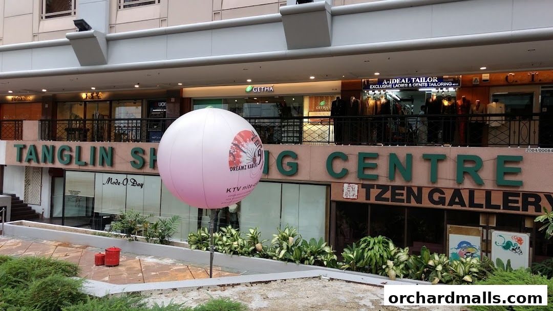 Exterior view of Tanglin Shopping Centre with various shops and a large inflatable balloon.