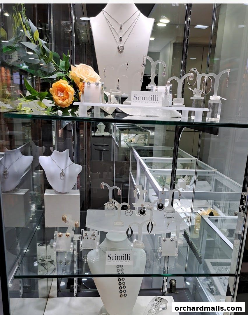 A display case filled with elegant necklaces, earrings, and floral decorations.