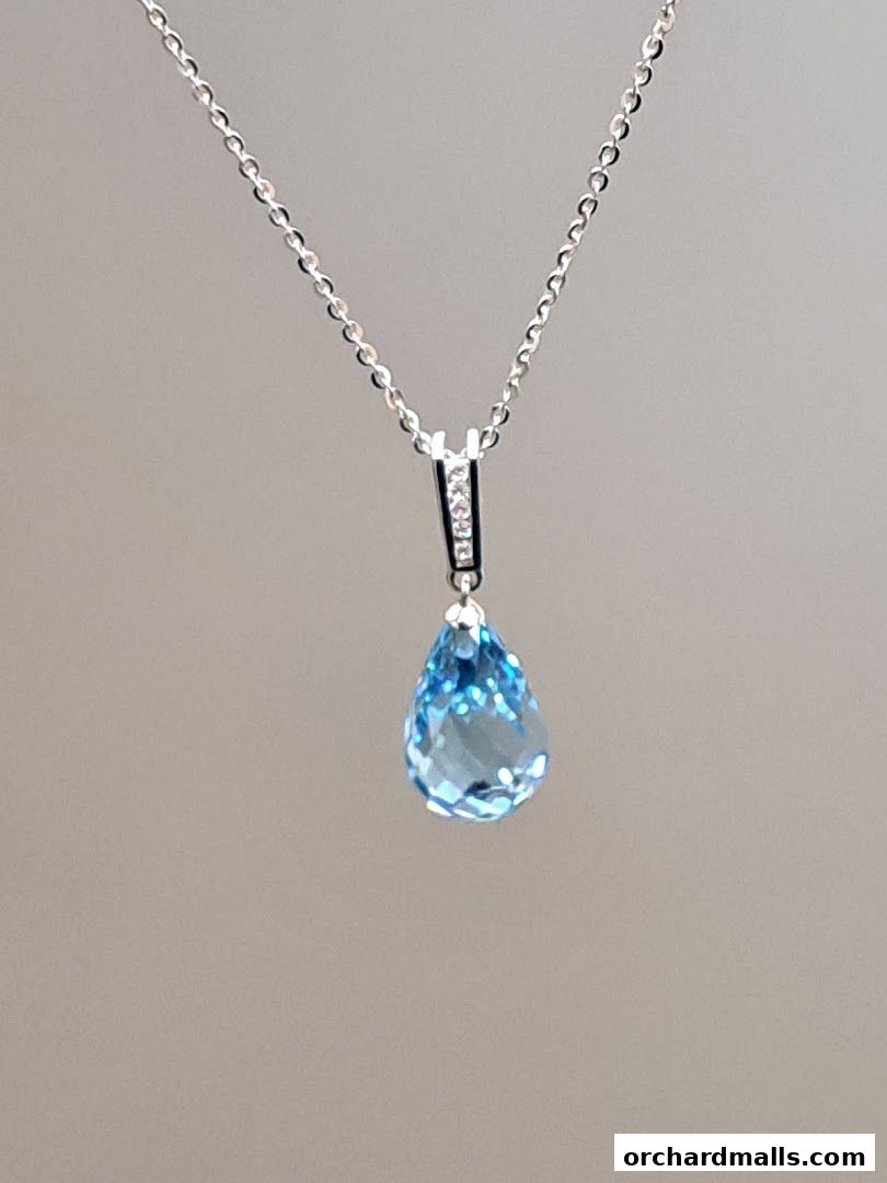 A delicate silver necklace with a teardrop-shaped blue gemstone pendant.