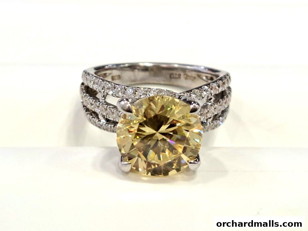 A close-up shot of a stunning yellow diamond ring with diamond-encrusted band.