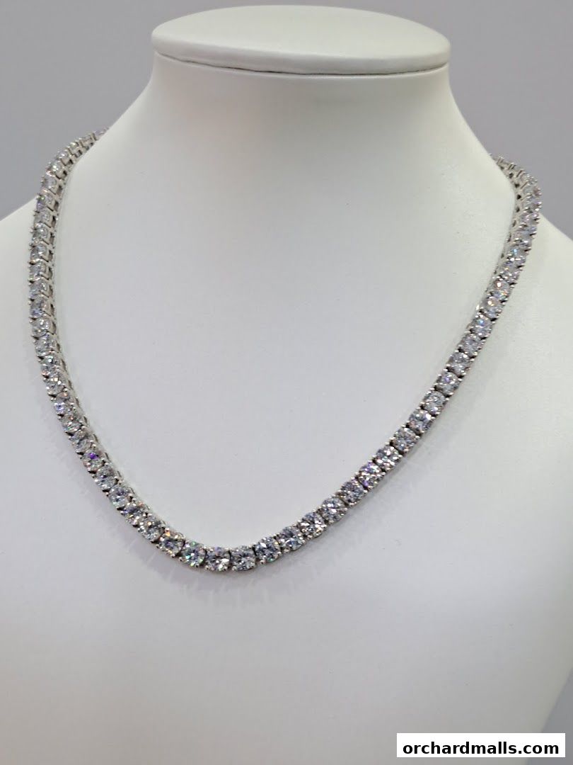 A dazzling diamond tennis necklace displayed on a white mannequin bust.