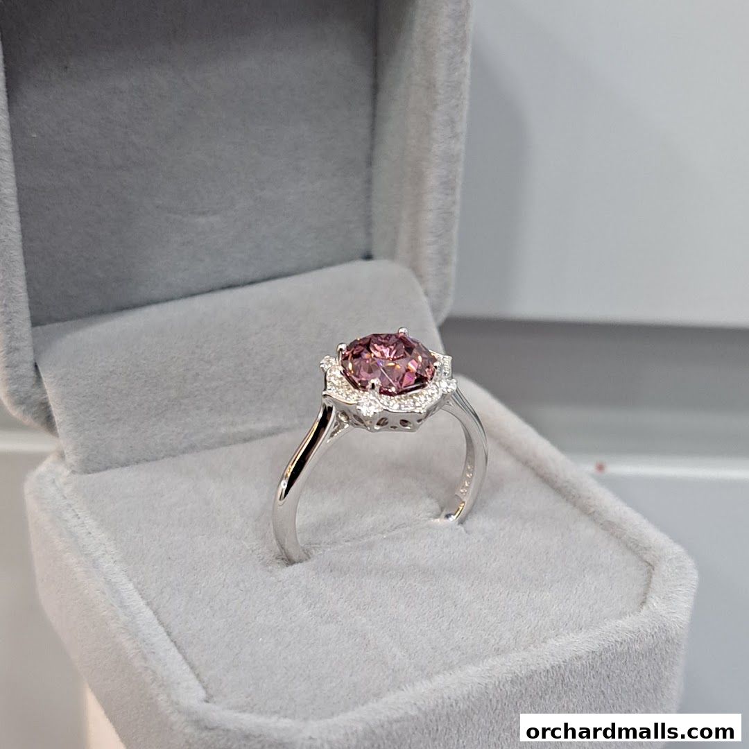 A stunning pink gemstone ring with diamond accents in a velvet jewelry box.