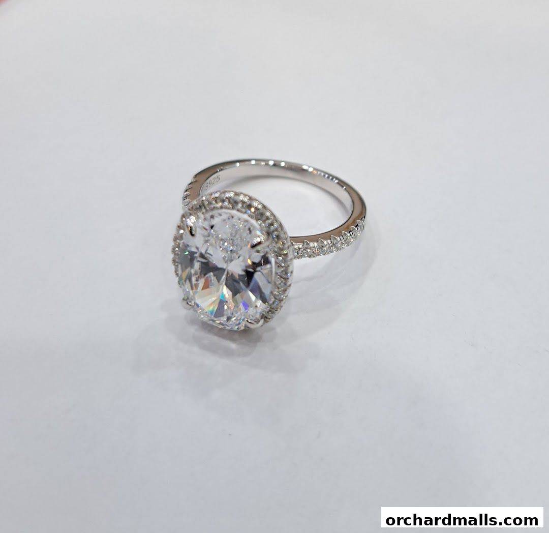A sparkling oval-cut diamond ring with a halo of smaller stones on a white background.