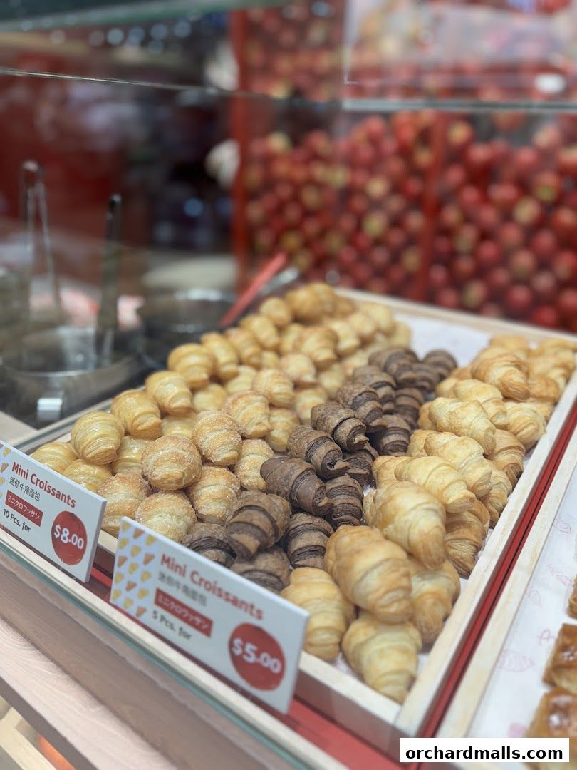 A display of assorted mini croissants, including plain, chocolate, and sugar-coated varieties.