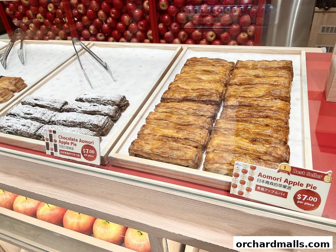 Display of freshly baked apple pies and chocolate apple pies at a bakery.