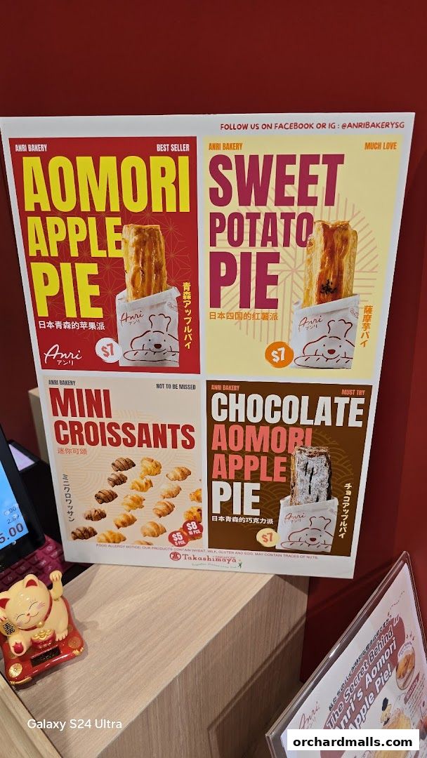 A display board showcasing various pies and croissants from Anri Bakery.