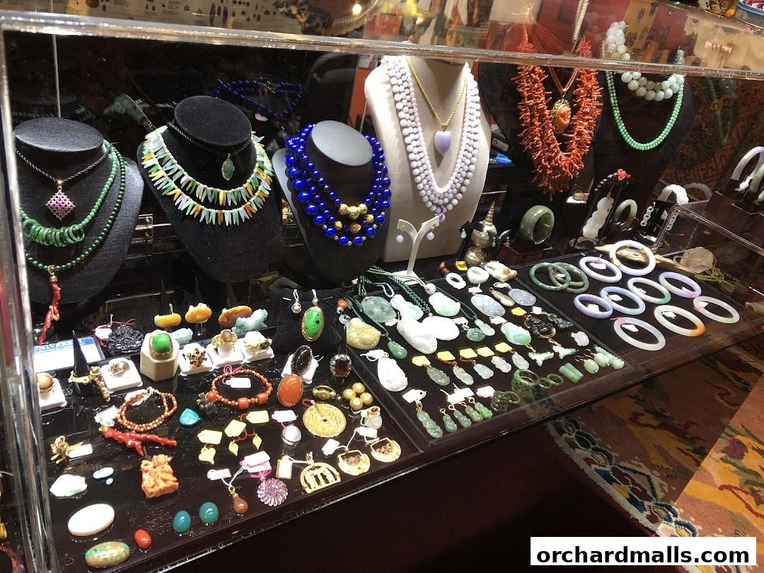 A display case filled with various necklaces, bracelets, rings, and pendants made of gemstones and coral.