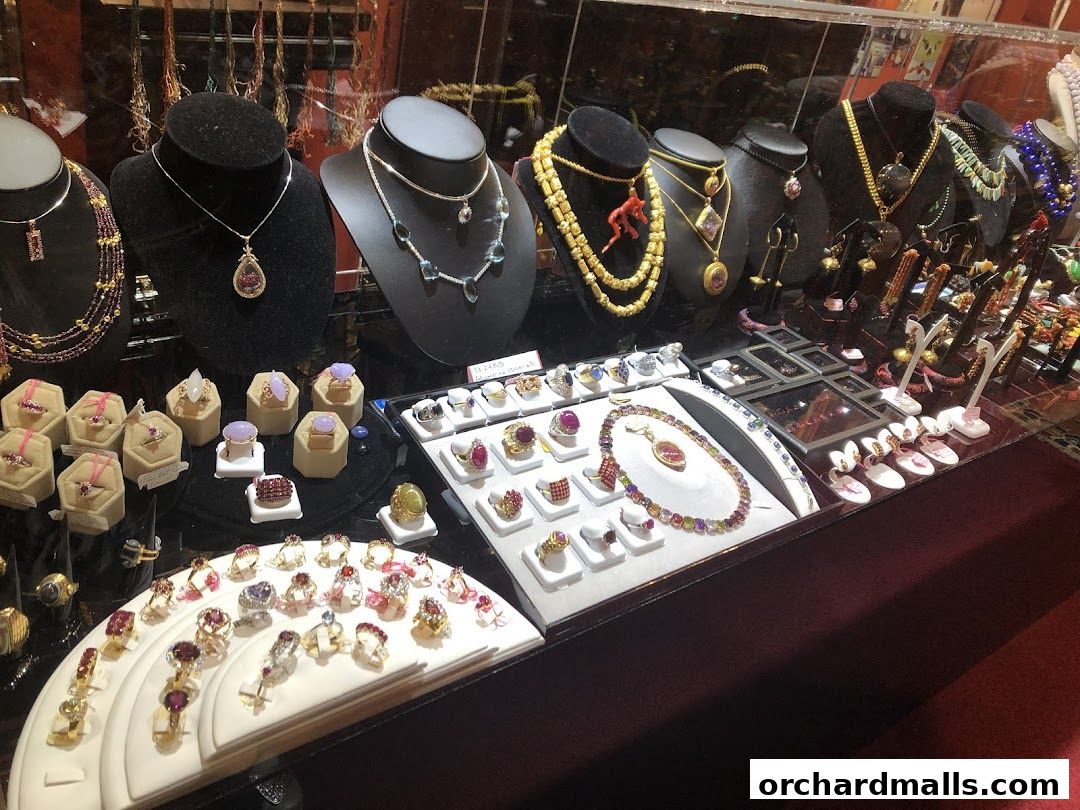 A display of exquisite jewelry, including necklaces and rings, featuring gemstones and intricate designs.
