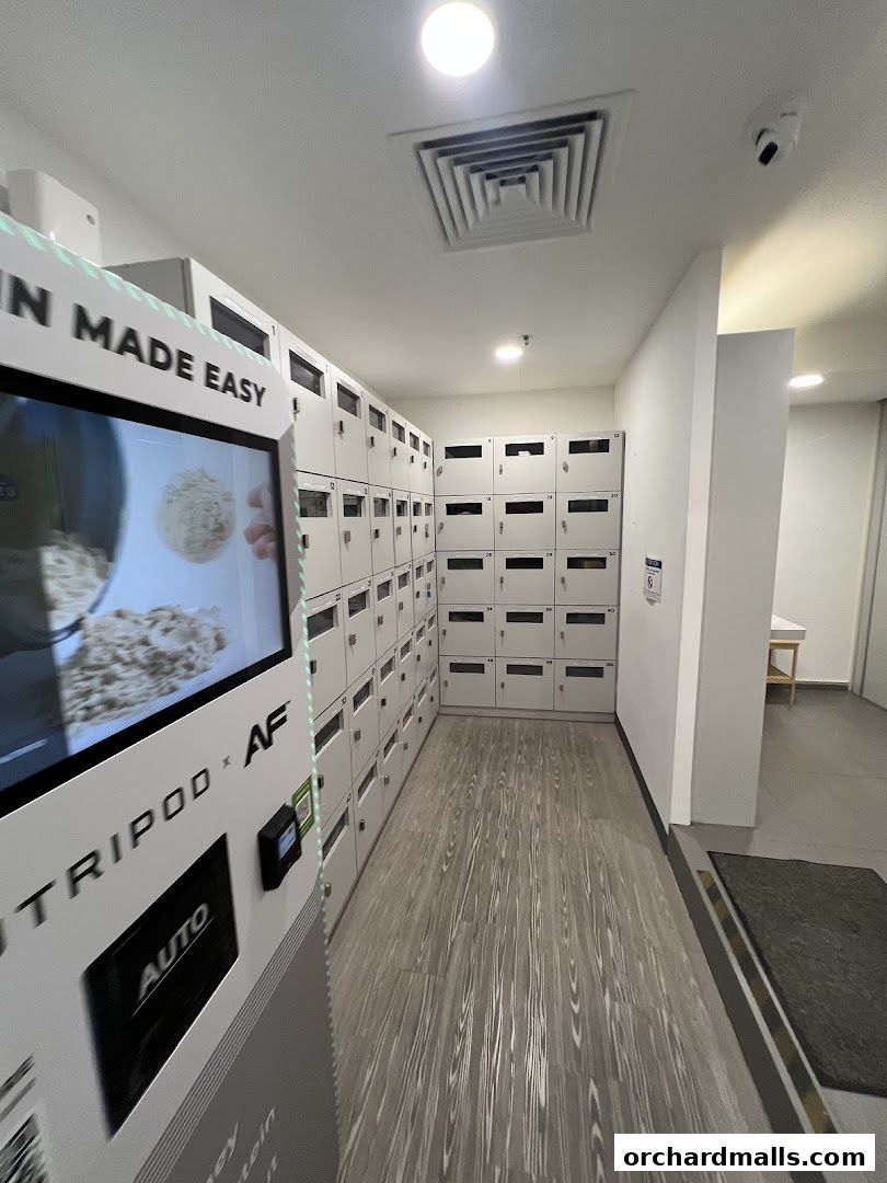 Interior view of a gym with lockers and a protein dispenser machine.