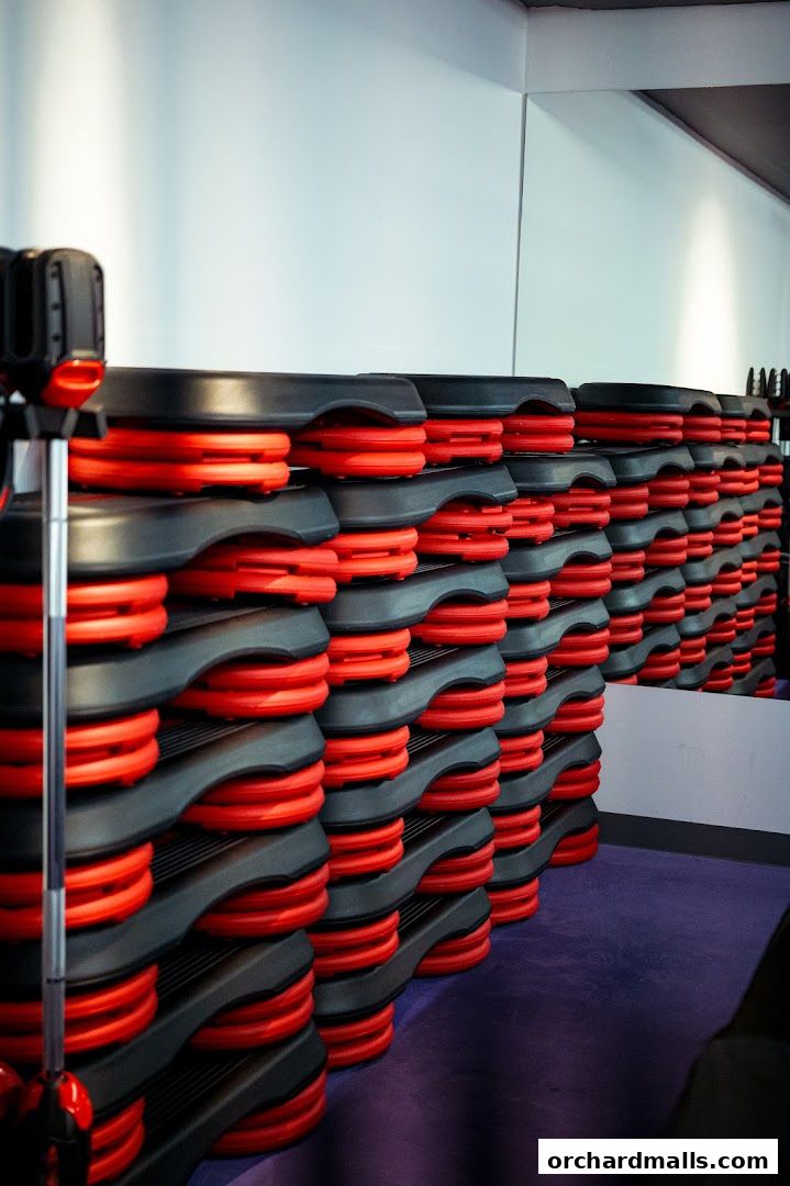 Stacked aerobic step platforms with red risers in a gym.