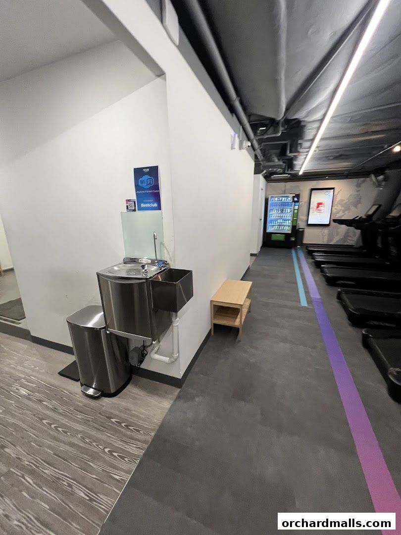 Interior view of Anytime Fitness with treadmills, vending machine, and water station.