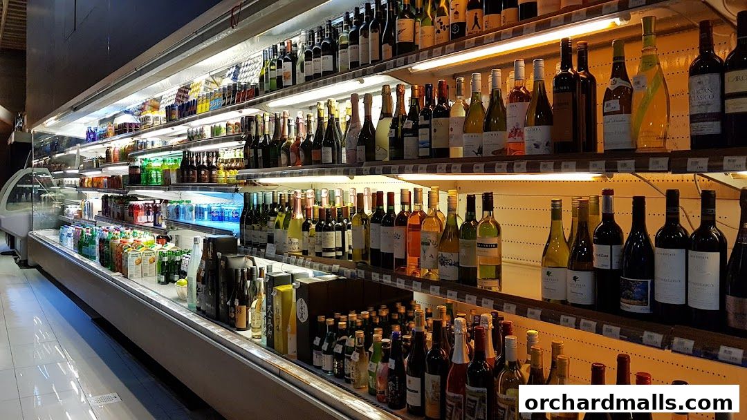 A wide selection of alcoholic beverages, including wine and spirits, displayed on refrigerated shelves.