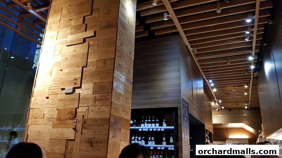 Interior of AP House with a pillar covered in wine crates and shelves of wine bottles.