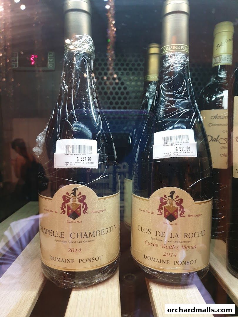 Two bottles of Domaine Ponsot wine, Chapelle Chambertin and Clos de la Roche, displayed in a retail setting.