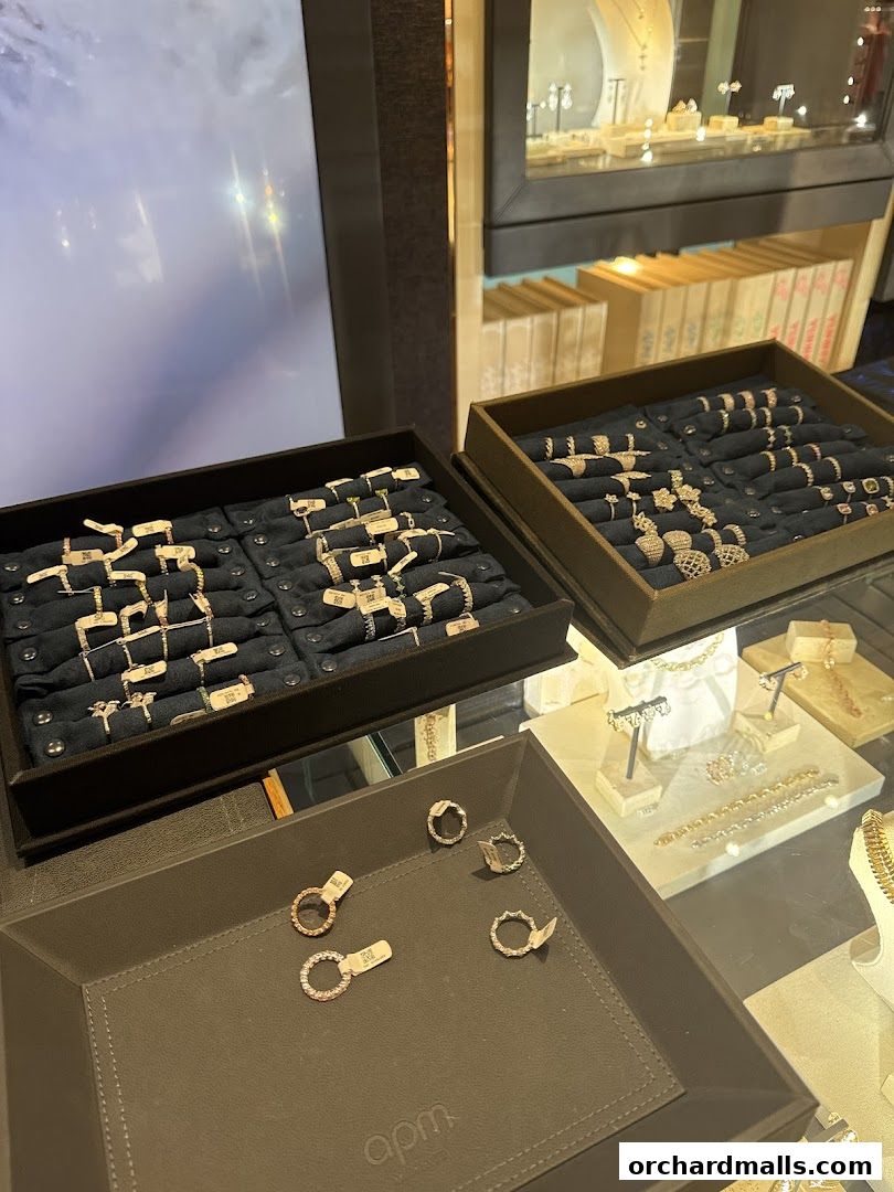 Display trays filled with various rings and jewelry, showcasing APM Monaco's collection.