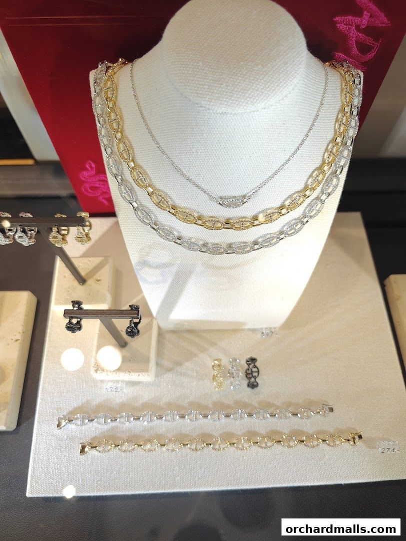 Display of elegant gold and silver necklaces and bracelets with diamond accents.