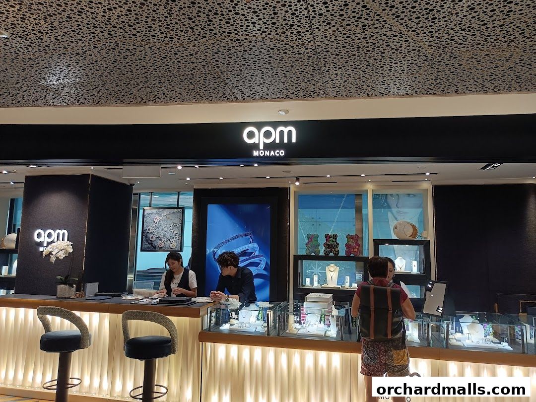 Interior view of APM Monaco Singapore ION Orchard jewelry store with staff and customers.