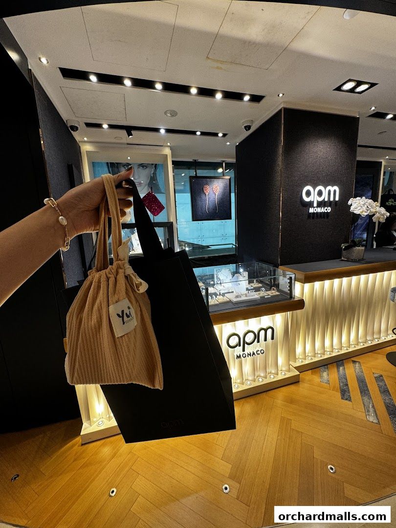 A person holds shopping bags in front of the APM Monaco store.