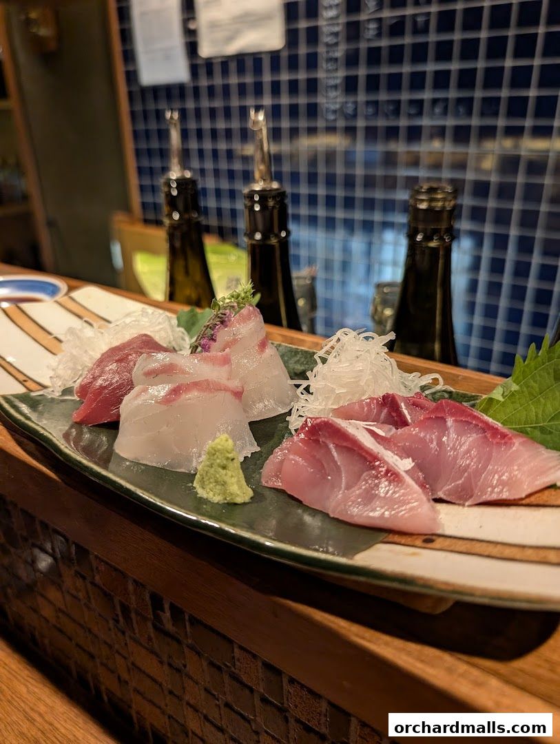 A plate of fresh sashimi with wasabi and shredded daikon radish.