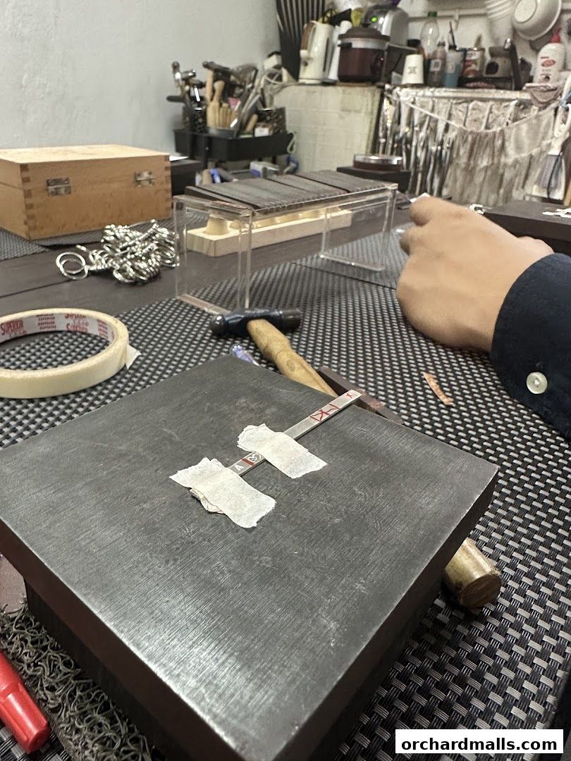 A close-up of a workbench with tools and materials for jewelry making.
