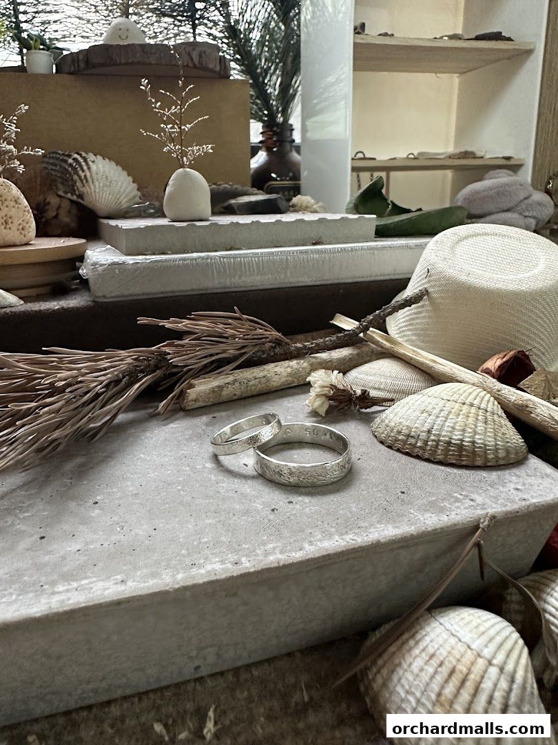 Artisan rings displayed with natural elements like shells and dried plants.