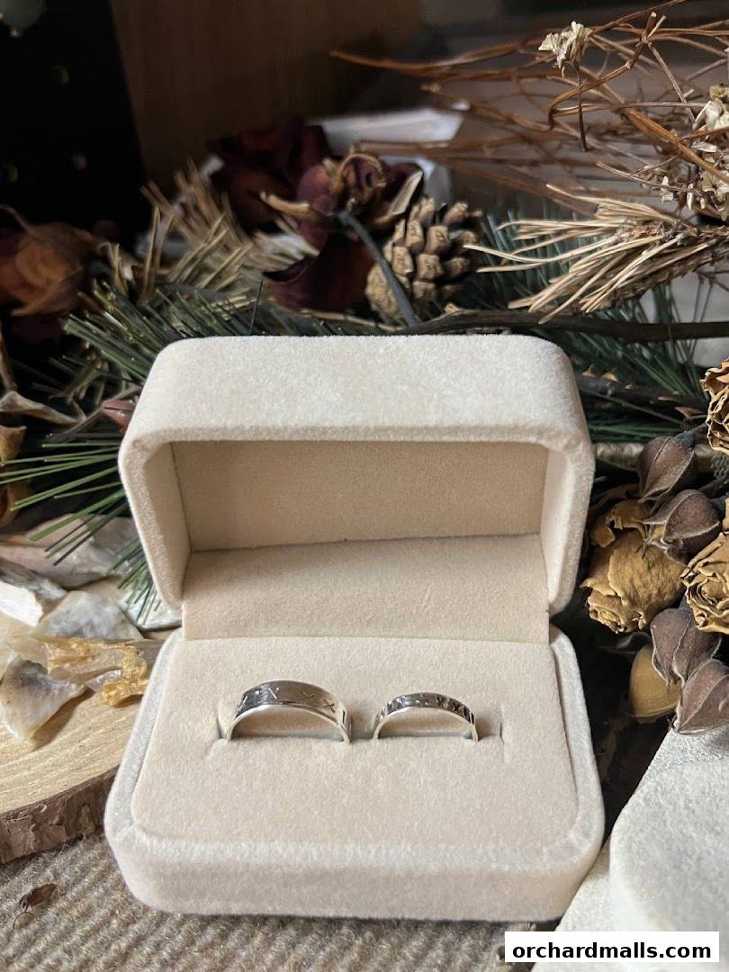 A velvet ring box displays two intricately designed silver rings with unique patterns.