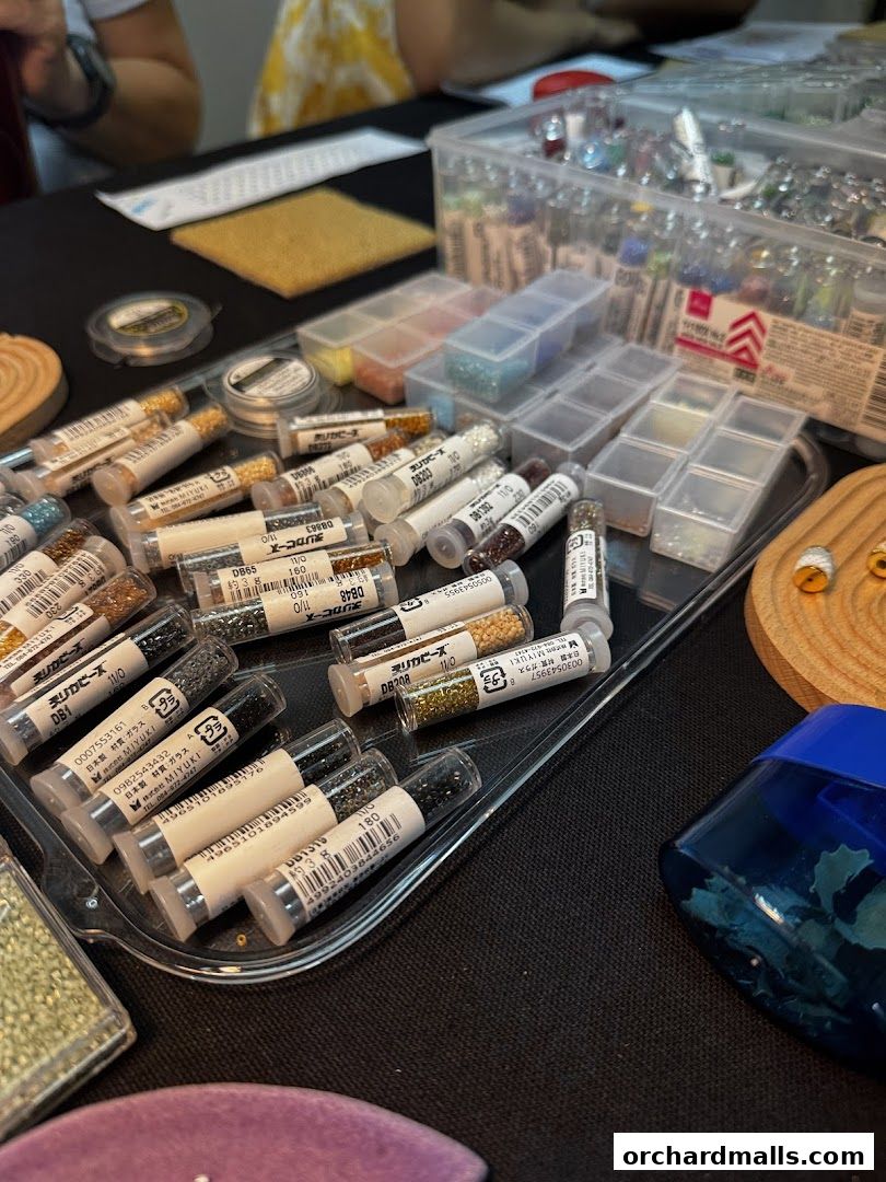 A close-up of various small beads in tubes and containers, likely for crafting.