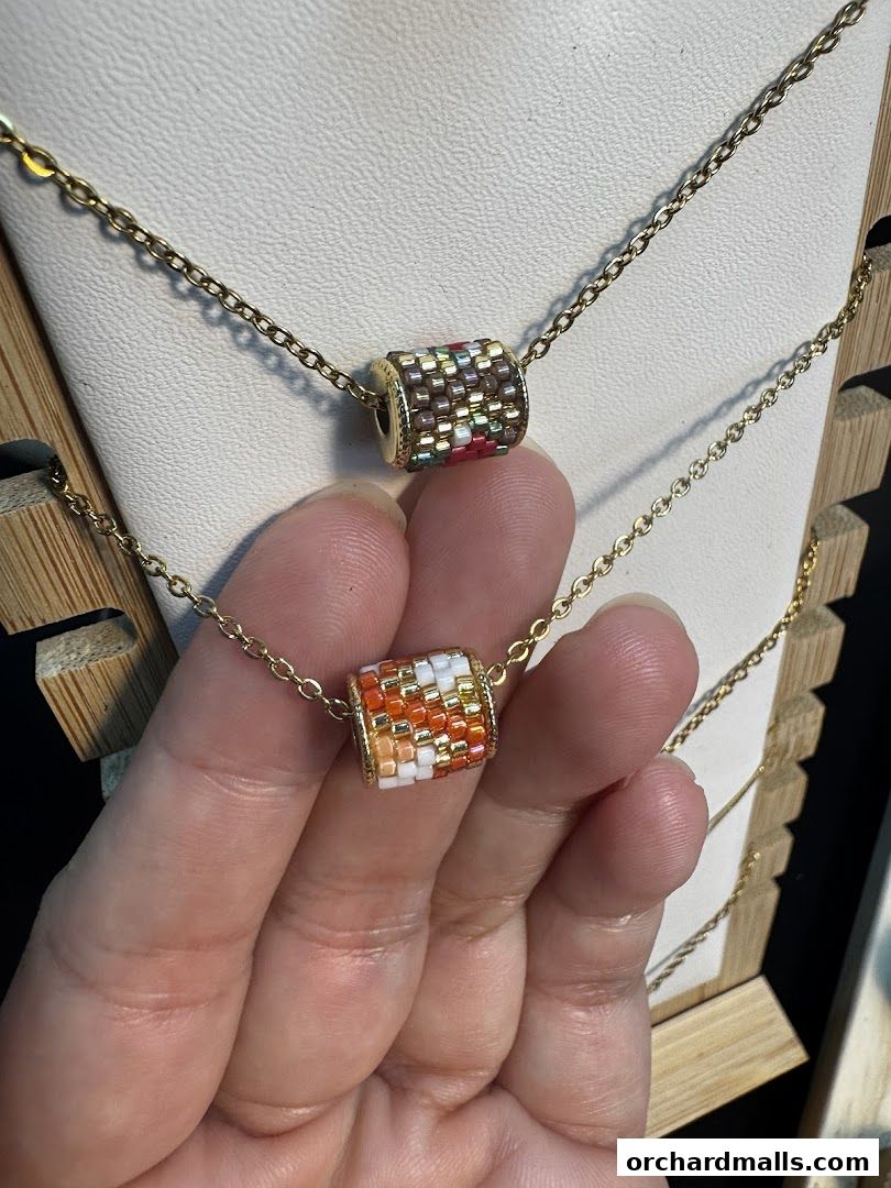 Close-up of two handmade beaded necklaces with gold chains.