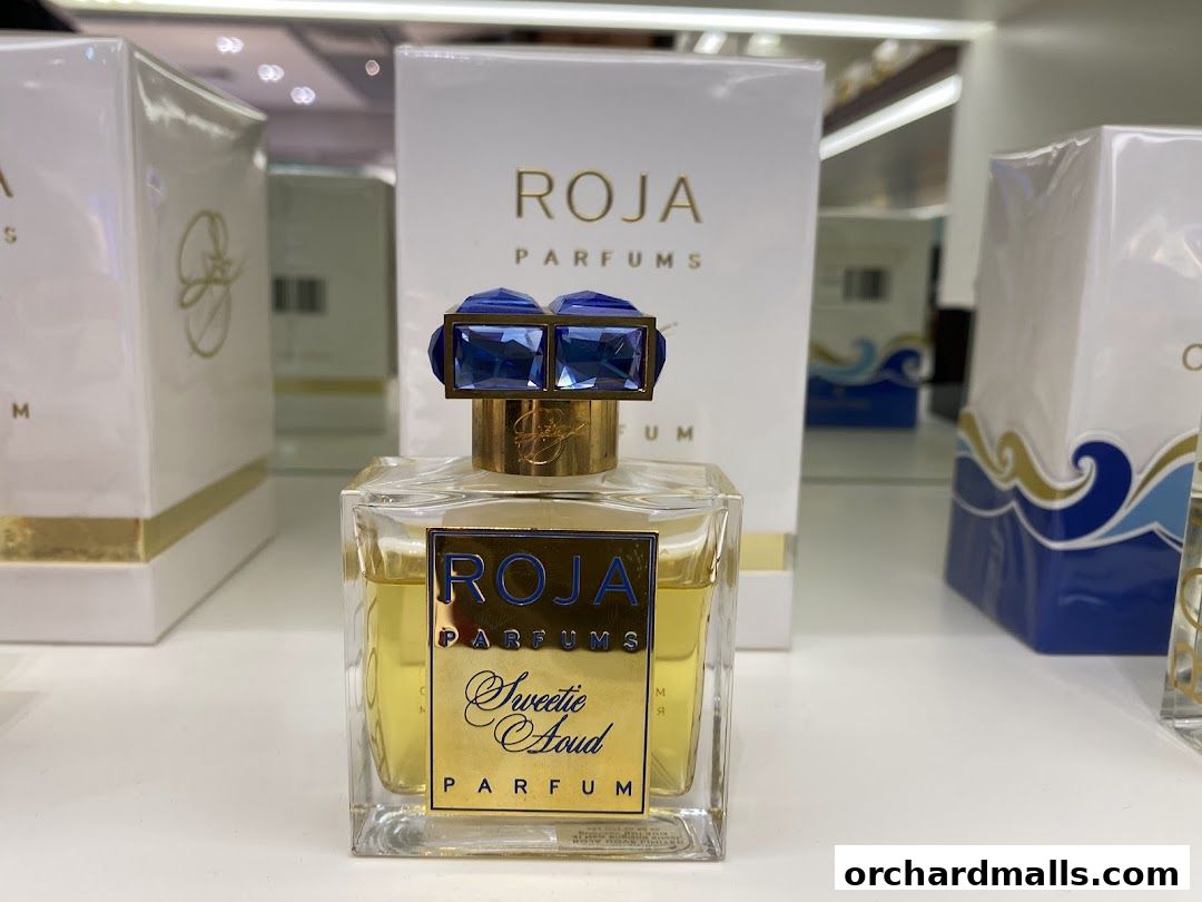 A close-up of a Roja Parfums 'Sweetie Aoud' perfume bottle with elegant packaging.