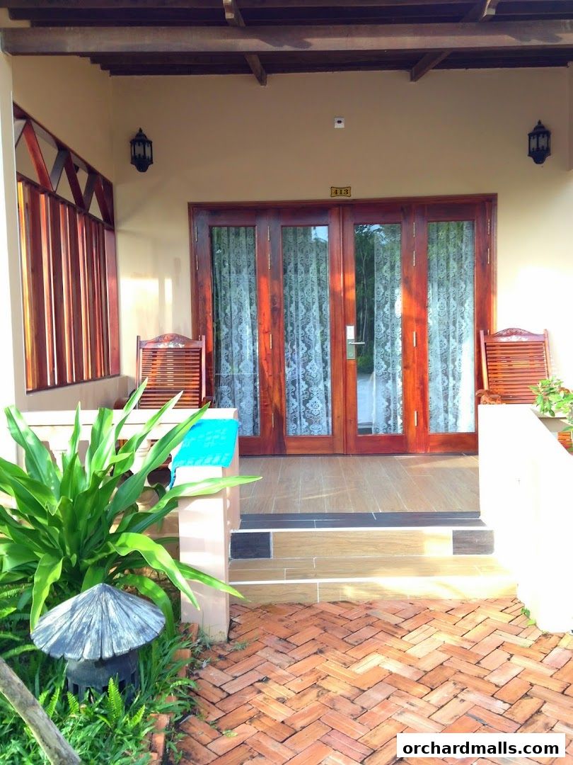 Exterior view of a shop entrance with wooden doors, chairs, and plants.