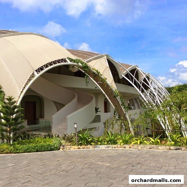 Exterior of a modern building with a unique curved roof and spiral staircase.