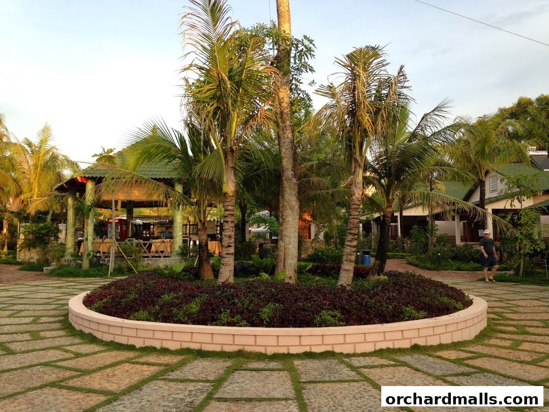 Tropical resort with palm trees, a covered dining area, and guest rooms.