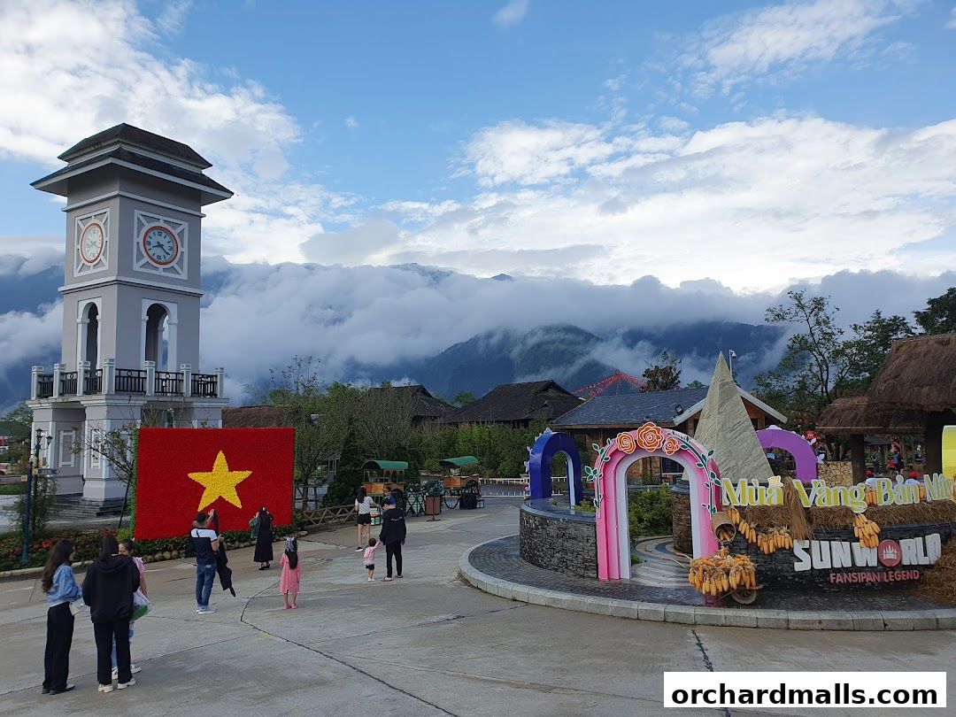 A scenic view of Sun World Fansipan Legend with a clock tower and Vietnamese flag.