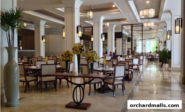 Elegant dining hall with tables set for meals and floral arrangements.
