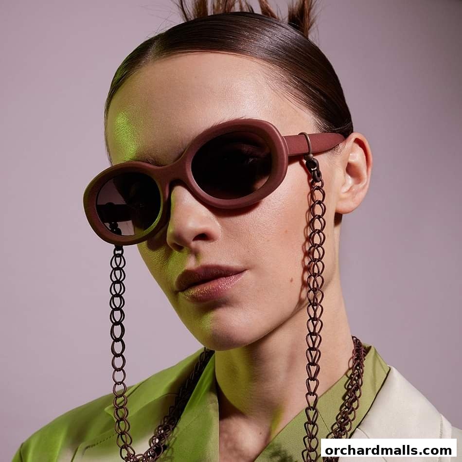 A close-up of a woman wearing stylish sunglasses with a chain accessory.