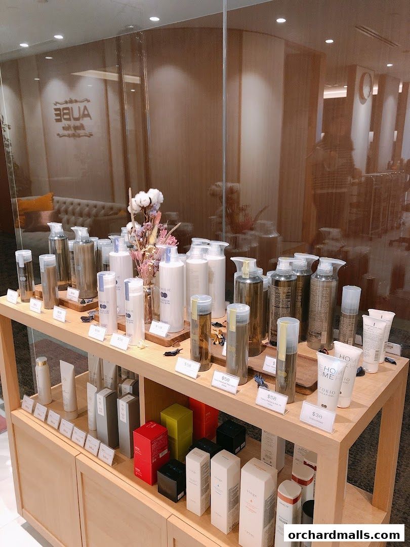 AUBE Beauty Salon Wheelock Place displays a variety of skincare and beauty products on wooden shelves.