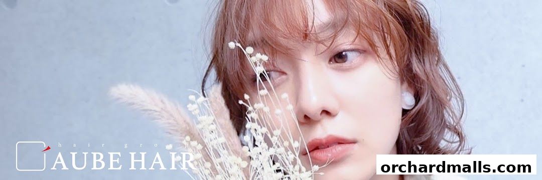 A close-up portrait of a woman with stylish hair, holding delicate dried flowers.