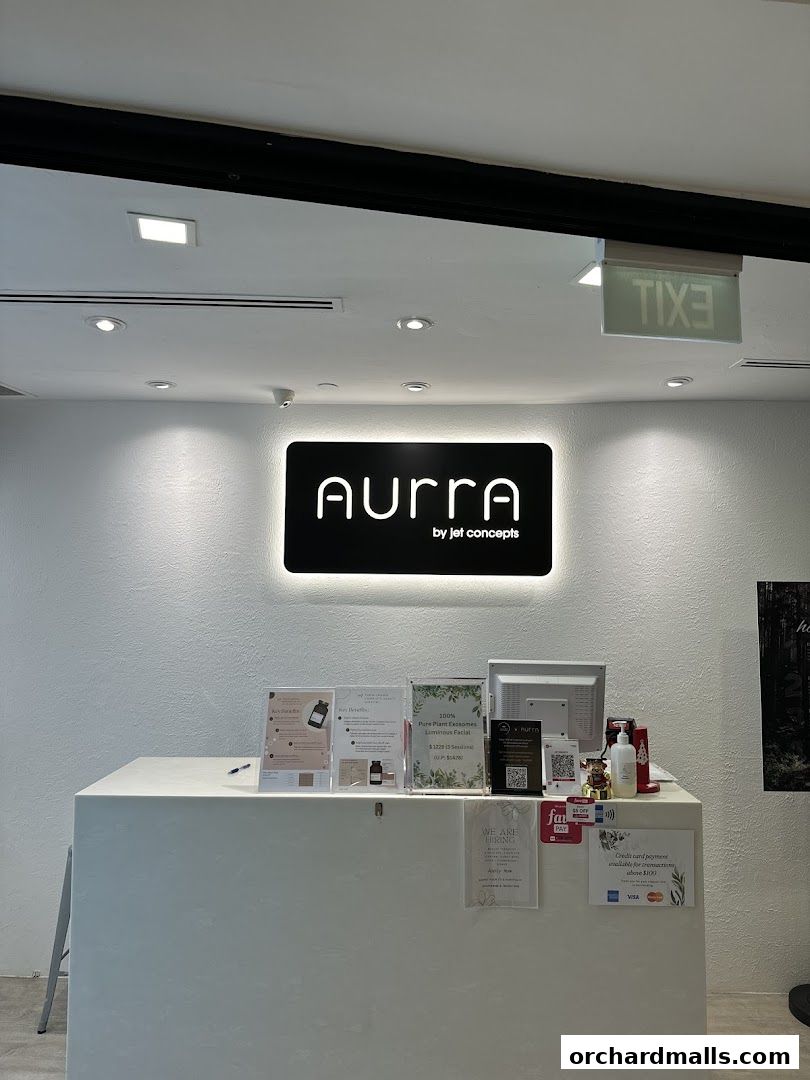 The reception area of AURRA by Jet Concepts, featuring a prominent logo and informational displays.