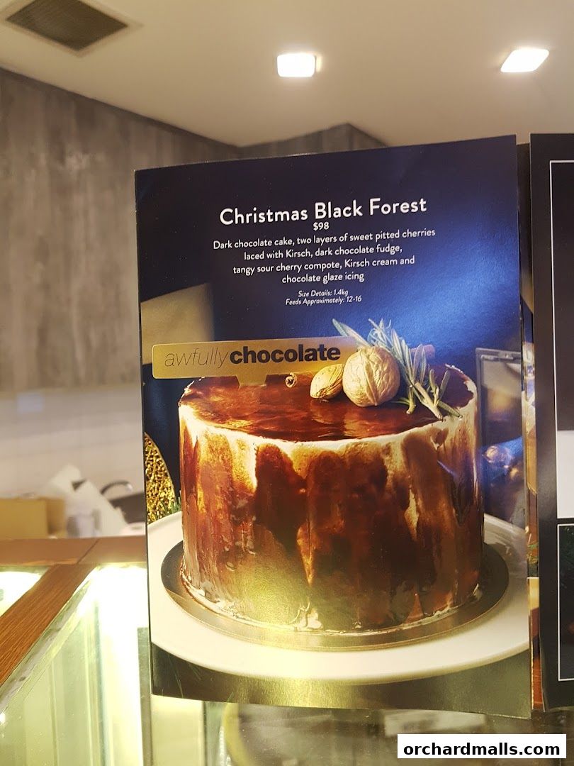 A close-up of a menu featuring a Christmas Black Forest cake from Awfully Chocolate.
