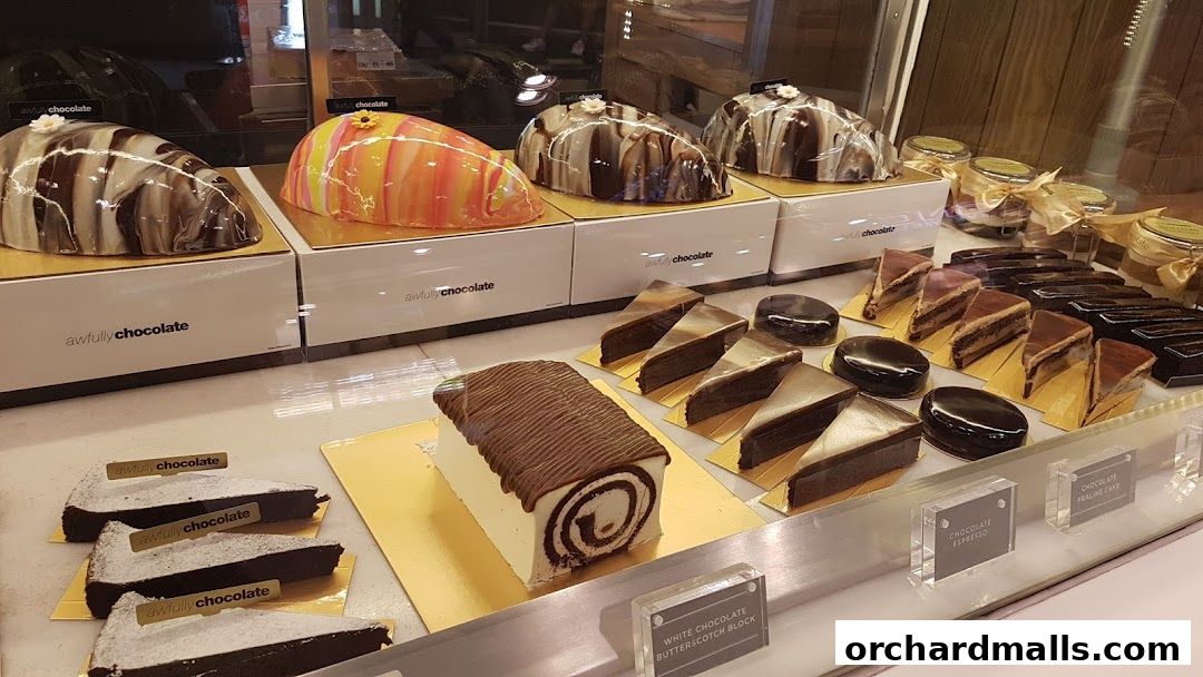 A display case filled with various chocolate cakes and desserts from Awfully Chocolate.