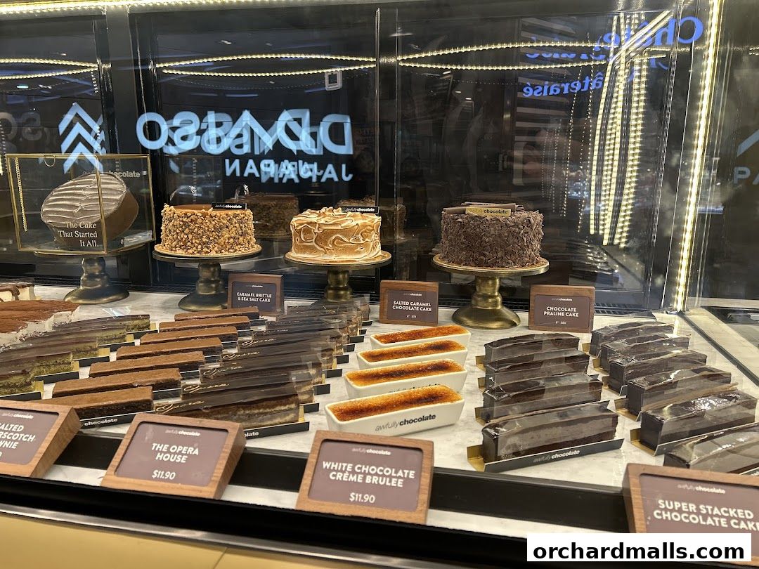A display case filled with various chocolate cakes, pastries, and desserts from Awfully Chocolate.