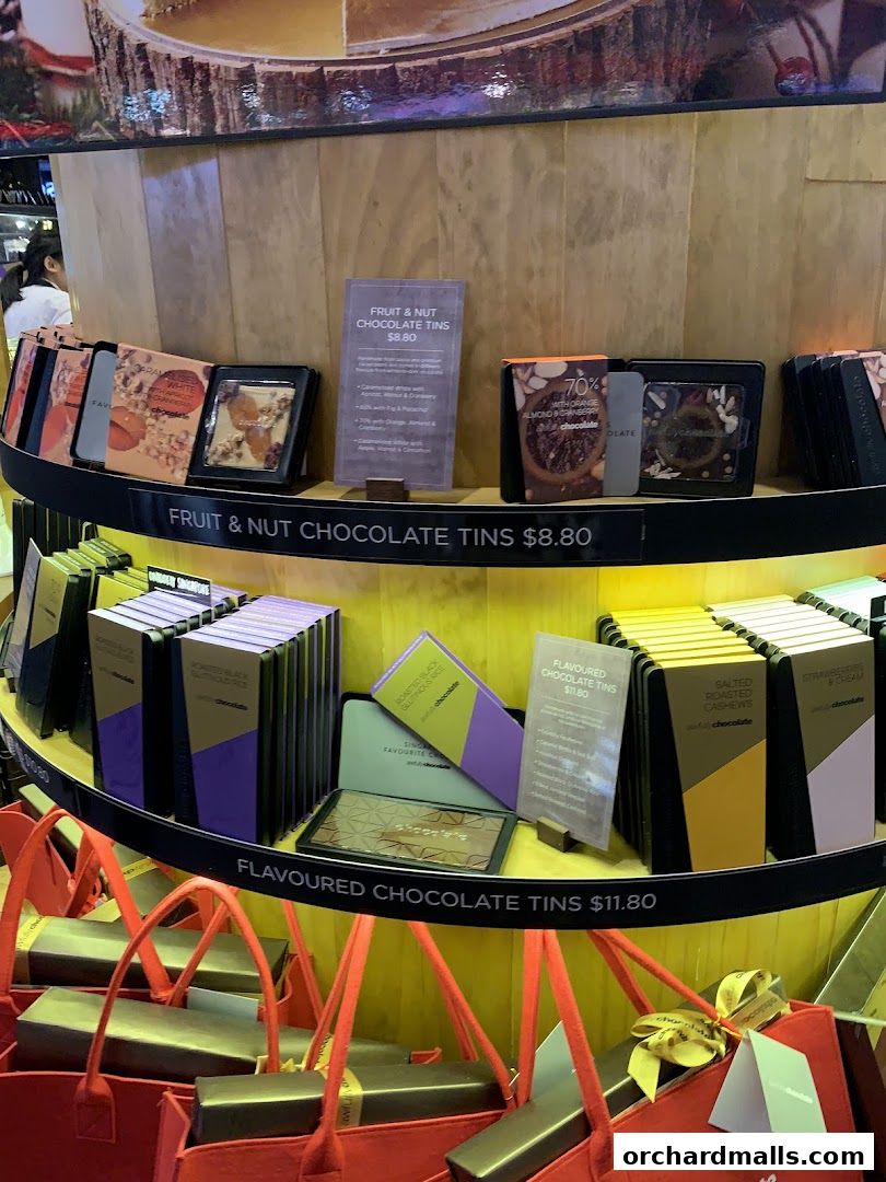 A display of various chocolate tins and gift bags at Awfully Chocolate.