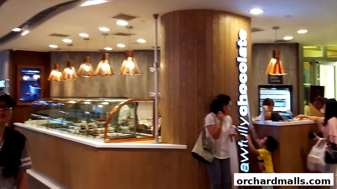 Interior of Awfully Chocolate shop with display cases and customers at the counter.